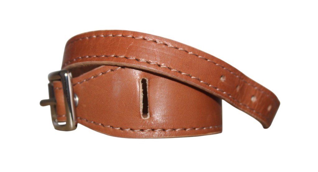 Le bracelet large en cuir camel avec boucle et lanière.